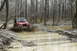 1995 Ford Bronco - Jeep Wrangler navigating a muddy obstacle in a wooded area.
