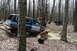 1995 Ford Bronco - Multiple SUVs navigate a muddy trail through a dense forest.