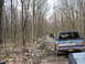 1991 Ford Bronco - A blue Chevrolet K5 Blazer navigates a wooded dirt road, with another vehicle visible ahead.
