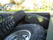 1997 Ford F-250 - Several large off-road tires are loaded into the bed of a pickup truck.