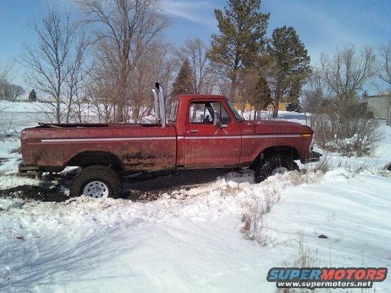 Red 1978 Ford F-150 stuck in snow with tall exhaust pipes