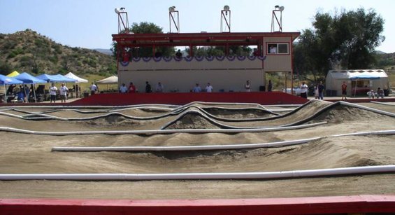RC car track with dirt jumps and a grandstand structure