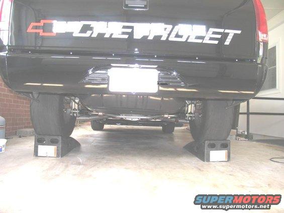 1990 Chevrolet Silverado 1500 rear view, lifted on jack stands. Large tires visible
