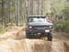 1989 Ford Bronco - A dark gray Ford Bronco navigates a muddy off-road trail.
