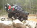 1989 Ford Bronco - Ford Bronco tackling a challenging off-road trail, with another Bronco visible further back.