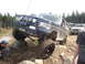 1989 Ford Bronco - A dark blue 1989 Ford Bronco navigates a rocky trail, with other vehicles visible in the background.
