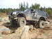 1989 Ford Bronco - A black Ford Bronco navigates a rocky off-road course with a driver inside.