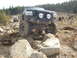 1989 Ford Bronco - A modified black Ford Bronco tackles a rocky trail with another vehicle following behind.