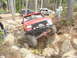 1989 Ford Bronco - Multiple off-road vehicles navigate a rocky trail in a wooded area.