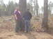 1989 Ford Bronco - Two men are standing in a forest clearing, surrounded by trees and underbrush.