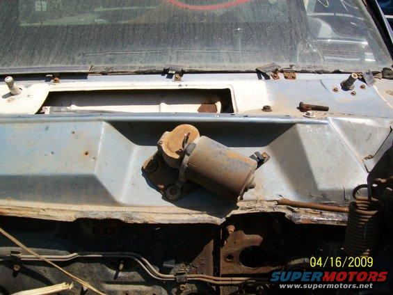 Windshield wiper motor on a rusty vehicle cowl