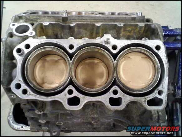 Engine block with three pistons visible