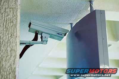 Security camera mounted on wall next to a monitor
