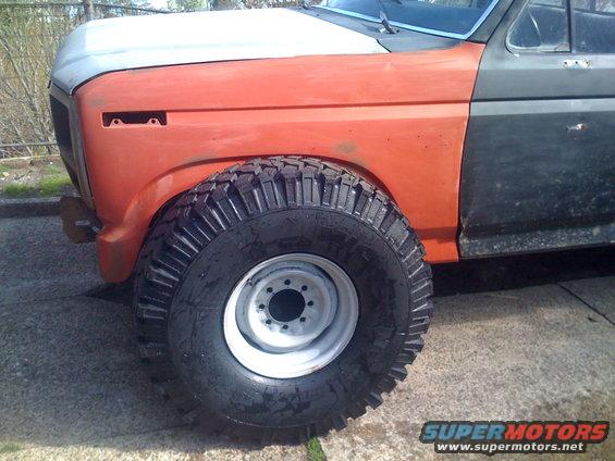 Front fender and large off-road tire on a Ford F-150, orange and gray paint