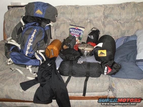 Kelty backpack, sleeping bags, and Mountain House meal on a couch