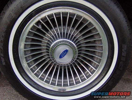 Ford wheel with whitewall tire and blue Ford logo