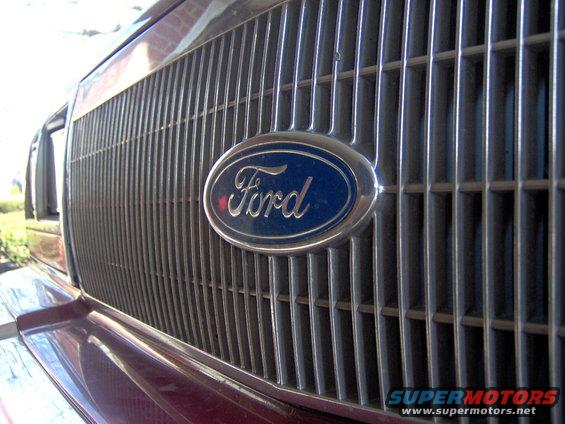 Close-up of a Ford oval emblem on a chrome grille