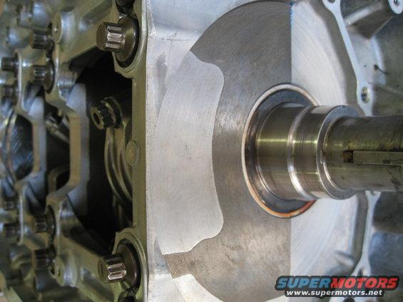 Close-up of an engine's internal components, showing a crankshaft, bearings, and part of the engine block with bolts