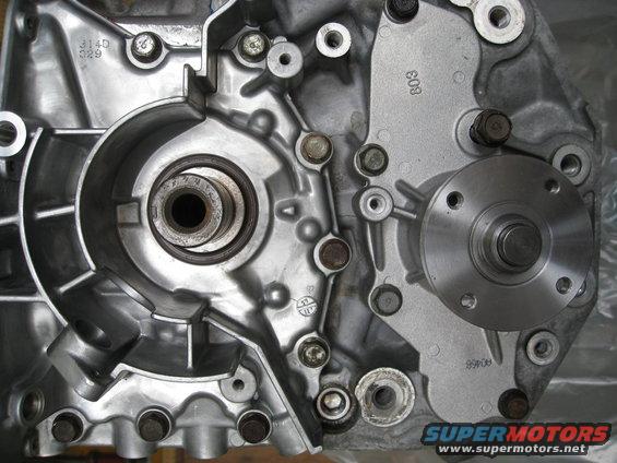 Close-up of a metal engine component with bolts and a circular flange