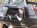 1979 Ford Bronco - A driver sits in a muddy black 1978 Ford Bronco, wearing a neck brace and giving a thumbs up.