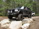 1979 Ford Bronco - This black Ford Bronco navigates a rocky trail, with another white SUV visible in the background.