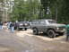 1979 Ford Bronco - A group of people and several off-road vehicles are gathered in a wooded area.