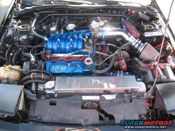 Engine bay with blue intake manifold labeled 3.0 V6