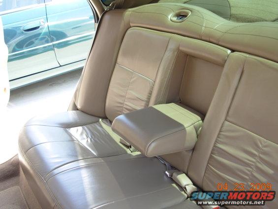 Tan leather interior with armrest and view of another car's side door