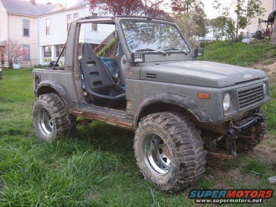 Suzuki Samurai with aftermarket seats and large tires parked on grass