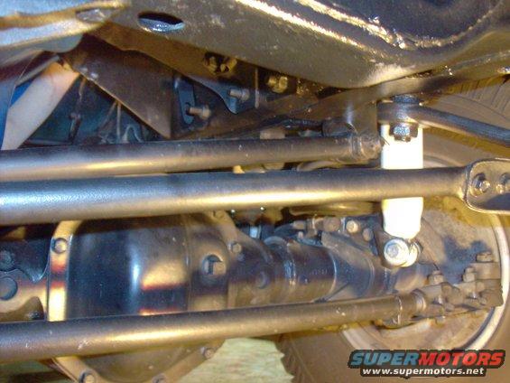 Undercarriage view of a vehicle's suspension and differential with visible "SUPERMOTORS" text