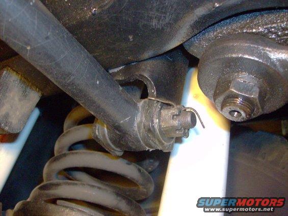 Close-up of suspension and steering components with Supermotors.net watermark