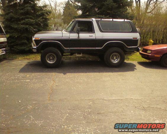 Two-tone black and silver Ford Bronco parked on asphalt, side view