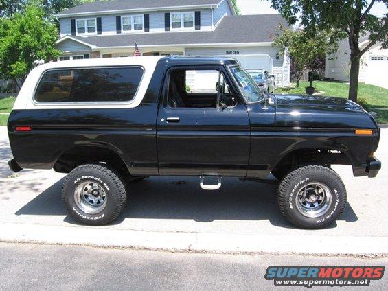 Black 1979 Ford Bronco with white removable top, side view