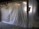 1987 Ford Bronco - A garage space is covered with plastic sheeting, likely for painting or dust containment, hiding the contents.