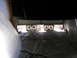 1987 Ford Bronco - Two fans are positioned in a garage doorway, set up on a plastic-covered floor.