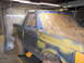 1987 Ford Bronco - A 1987 Ford Bronco is prepped for paint in a garage, with windows and body panels taped off.
