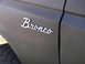 1987 Ford Bronco - The 'Bronco' emblem is clearly visible on the side of the vehicle, confirming its identity.