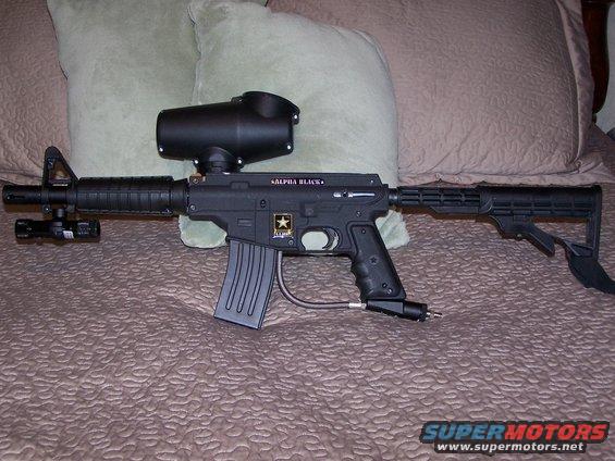 Paintball gun with hopper and stock, labeled "ALPHA BLACK"