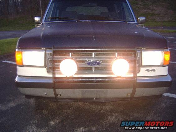 Front view of a dark SUV with fog lights and a brush guard. '4x4' badge visible
