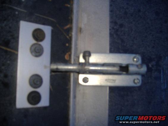 Door bolt latch mounted on a metal surface