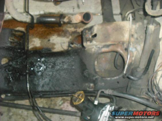 close-up of greasy vehicle frame with some hoses and pipes visible