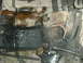 1982 Ford Bronco - Underside view of a vehicle's frame, showing engine components and signs of wear and tear.