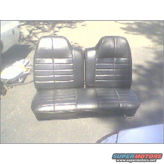 Two black vinyl car seats with horizontal pleating, stacked on top of each other