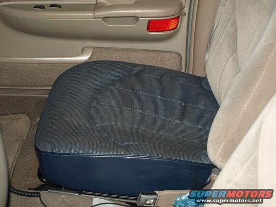 Interior view of a car seat and part of the ceiling with a taillight visible