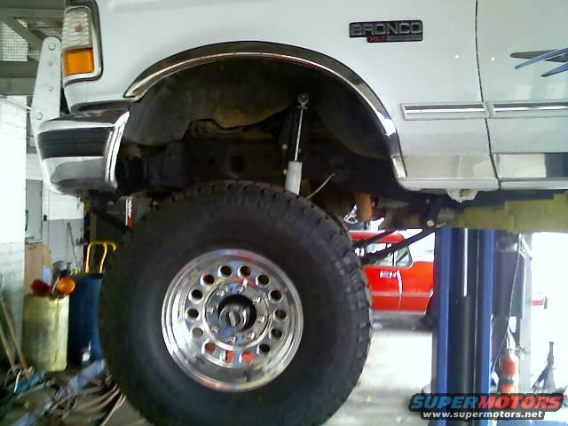 White 1996 Ford Bronco side view, lifted with large tire