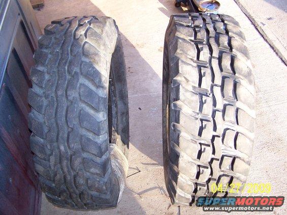 Two large off-road tires, one on the left with aggressive tread, the other on the right with blocky tread