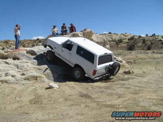 White 1993 Ford Bronco climbing rocky terrain