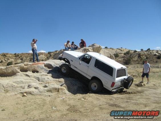 White 1993 Ford Bronco climbing rocky terrain