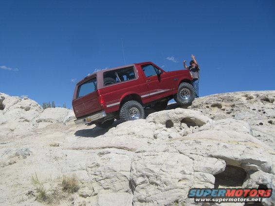 Red 1993 Ford Bronco climbing rocks