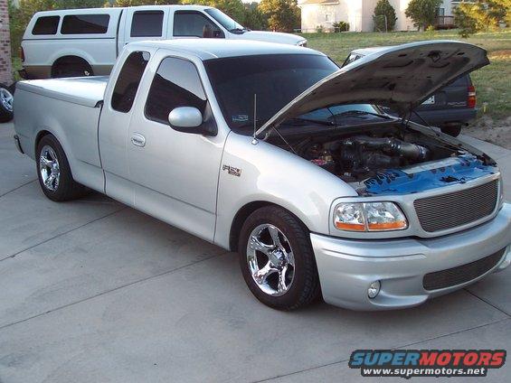 Silver 1998 Ford F-150 with hood open, showing engine and custom wheels
